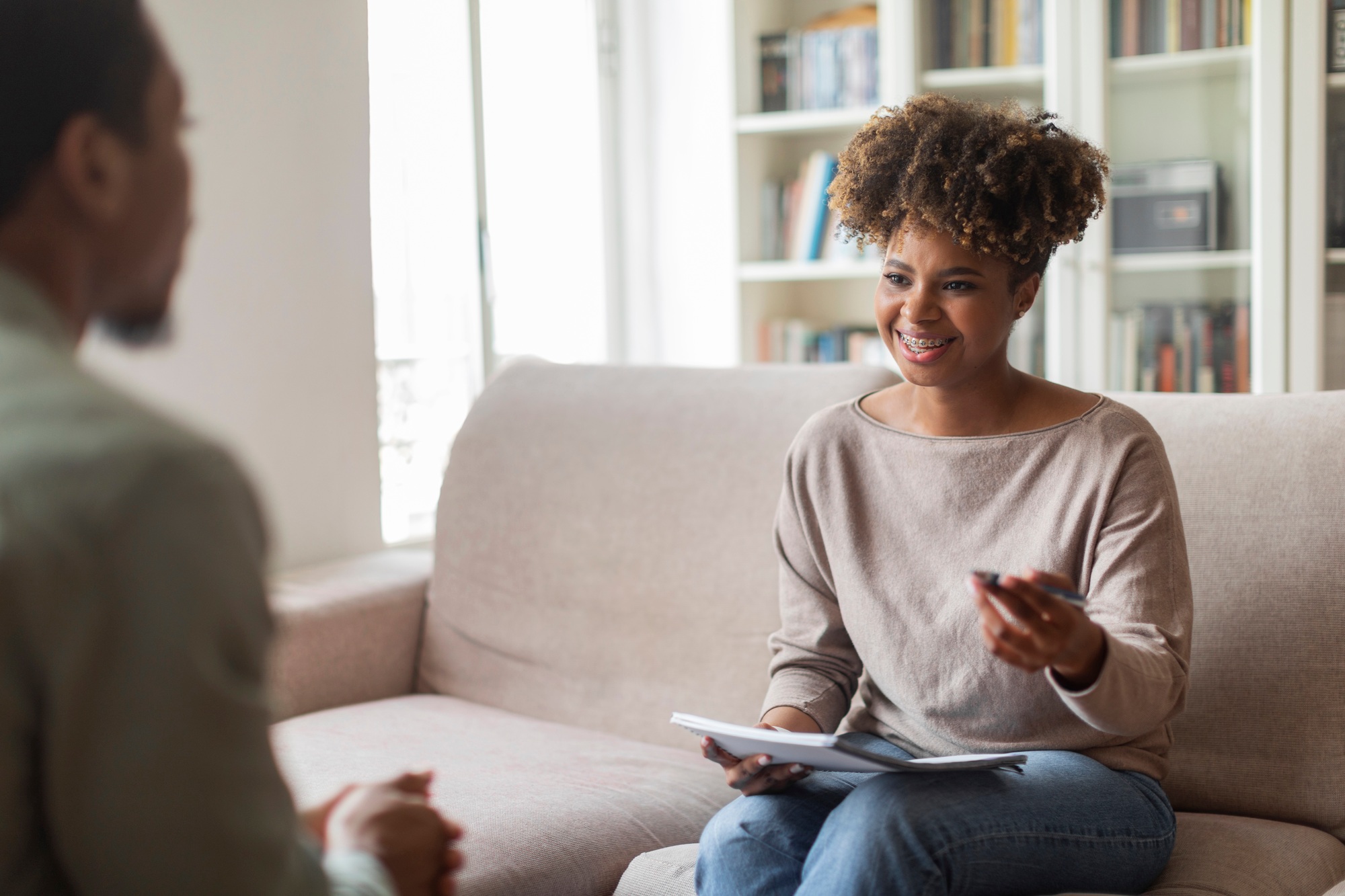 Smiling friendly black woman psychologist having conversation with patient